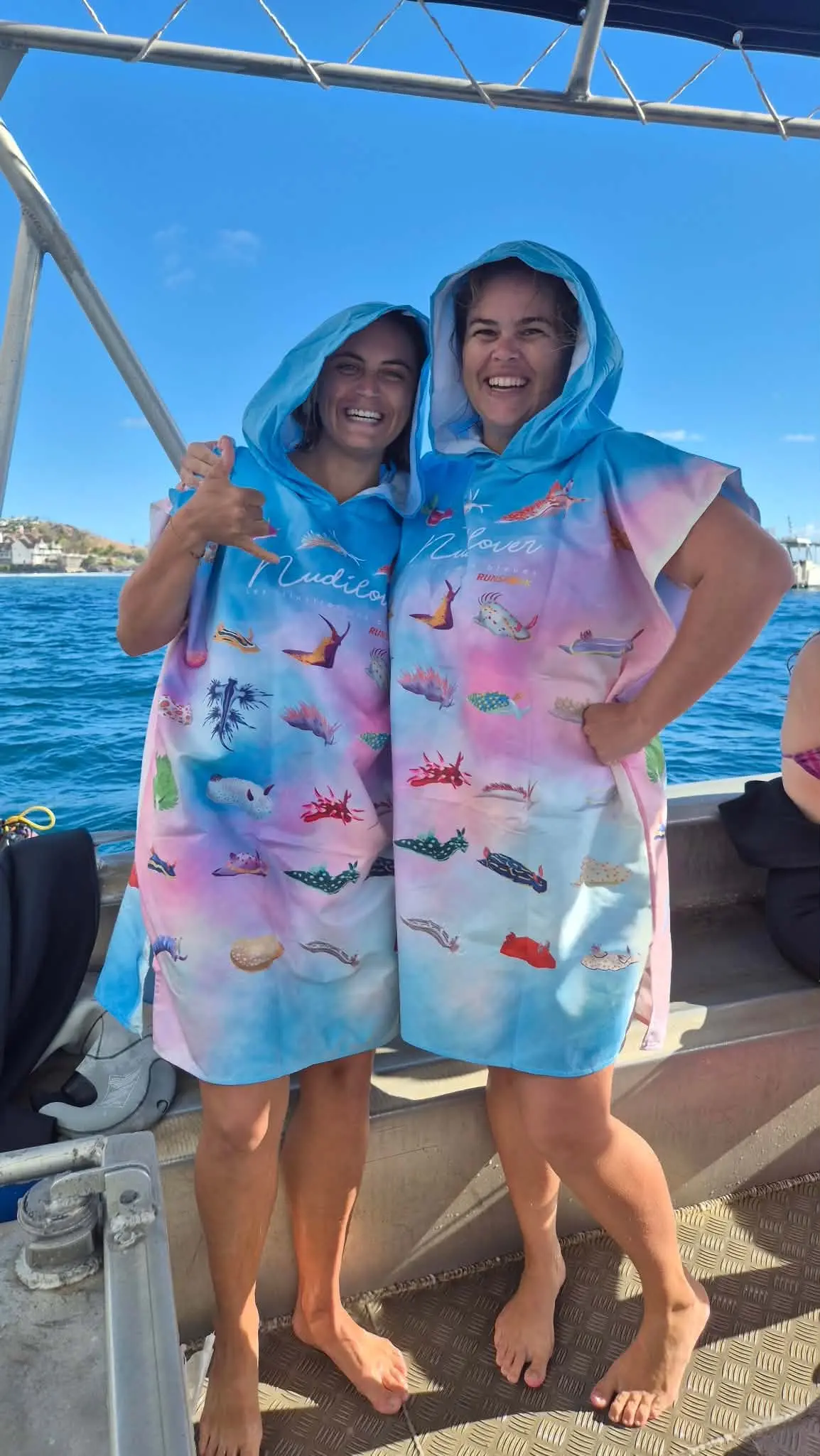 Deux plongeuses portent le poncho Nudilovers après leur sortie en mer.