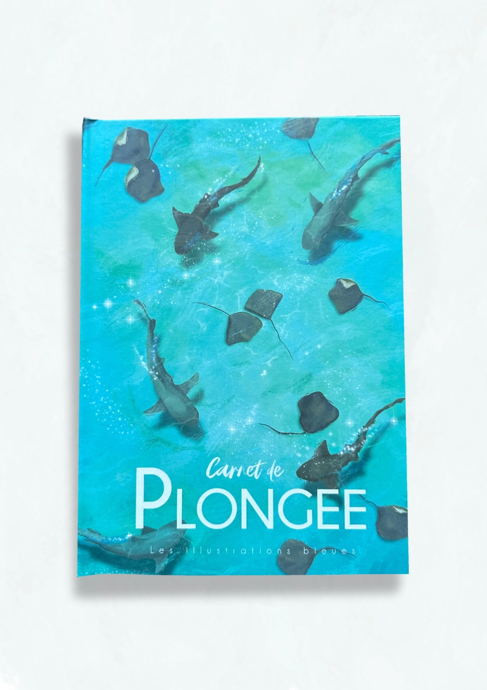 Couverture du joli carnet de plongée illustré montrant des raies et requins